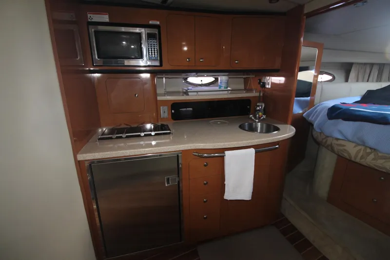 The galley of a 2008 Chaparral 350 Signature with microwave, stove, and sink.