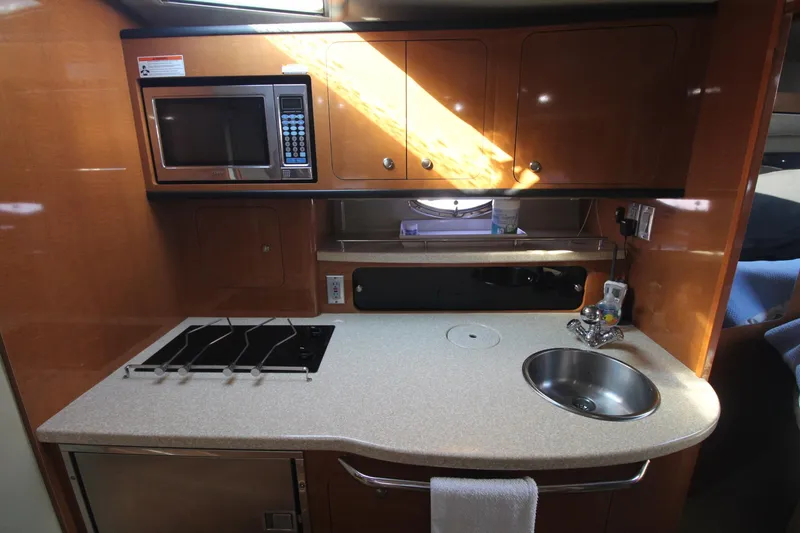 The galley of a 2008 Chaparral 350 Signature with a microwave, stove, and sink.
