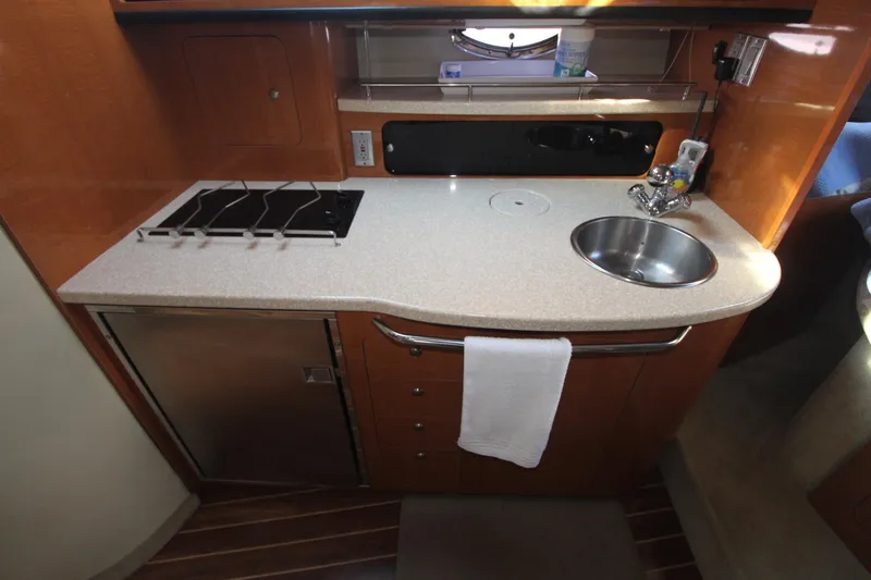 Compact galley with sink, stove, and fridge in a boat.