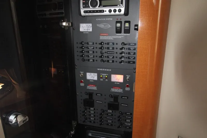 Electrical control panel with switches and displays inside a boat.