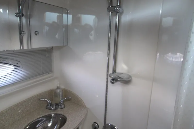 The image shows a modern boat bathroom with a sink and shower.