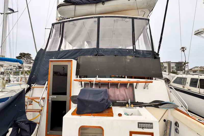 1985 Symbol 51 yacht with covered cockpit and visible marina background.