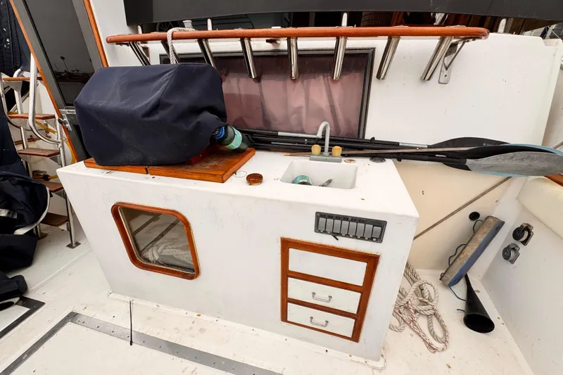 Outdoor boat sink area with storage, paddles, and covered equipment on a 1985 Symbol 51 model.