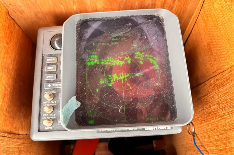 Vintage 1985 Symbol 51 radar display with green data on screen, housed in wooden enclosure.