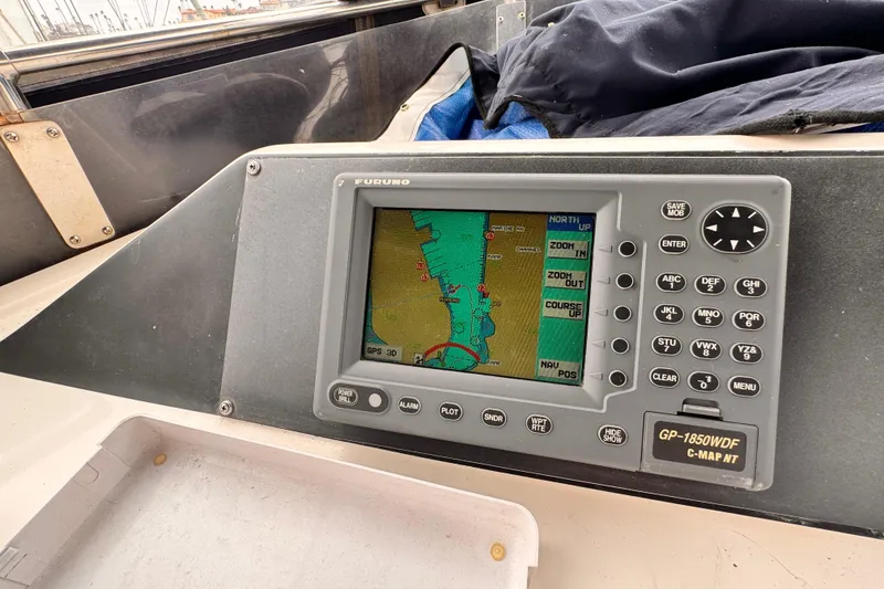 Boat navigation system with GPS display, showing a coastal map and control buttons.