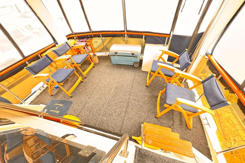 Enclosed boat deck with blue chairs and cooler, Symbol 51, 1985 model.