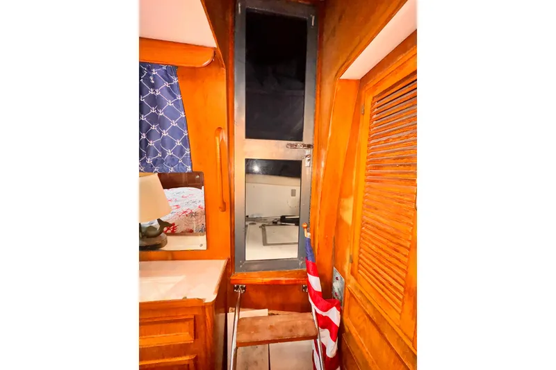 Cozy 1985 Symbol 51 yacht interior with wooden paneling and nautical decor.