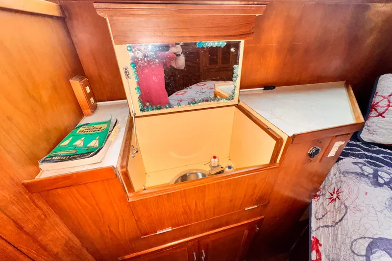 Wooden vanity with mirror and sink in a 1985 Symbol 51 boat interior.