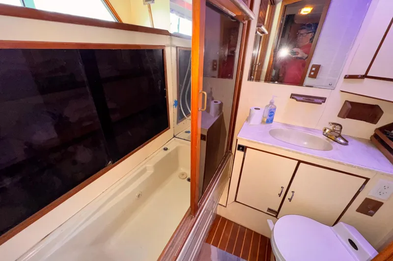 Compact 1985 Symbol 51 yacht bathroom with shower, sink, and toilet.