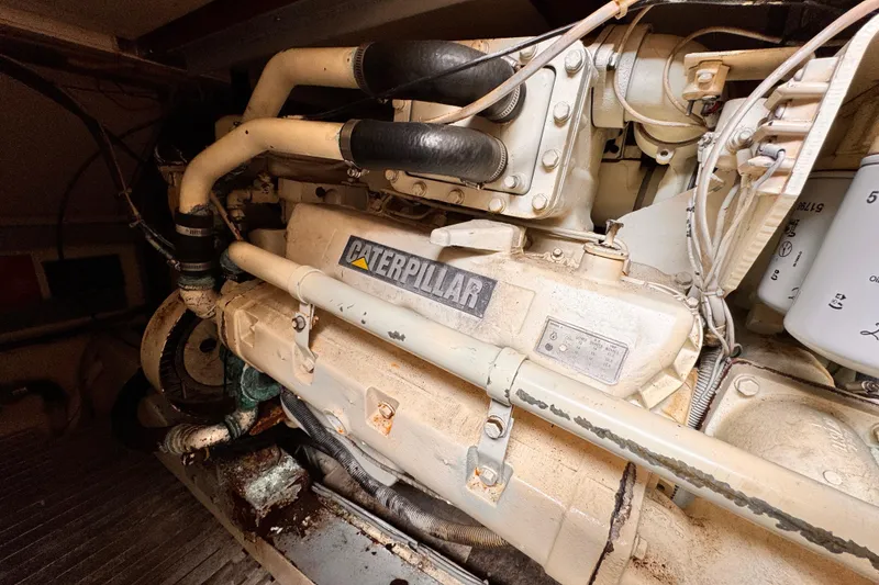 Engine room featuring a 1985 Caterpillar engine with visible pipes and components.