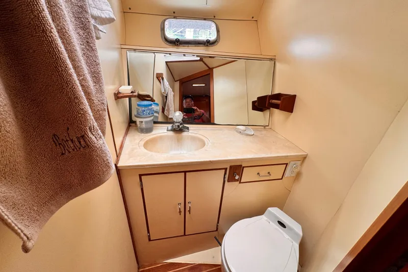 Compact 1985 Symbol 51 yacht bathroom with sink, mirror, and toilet.