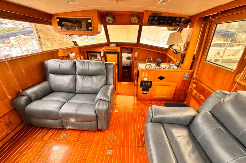Luxurious 1985 Symbol 51 yacht interior with leather seating and wooden finishes.