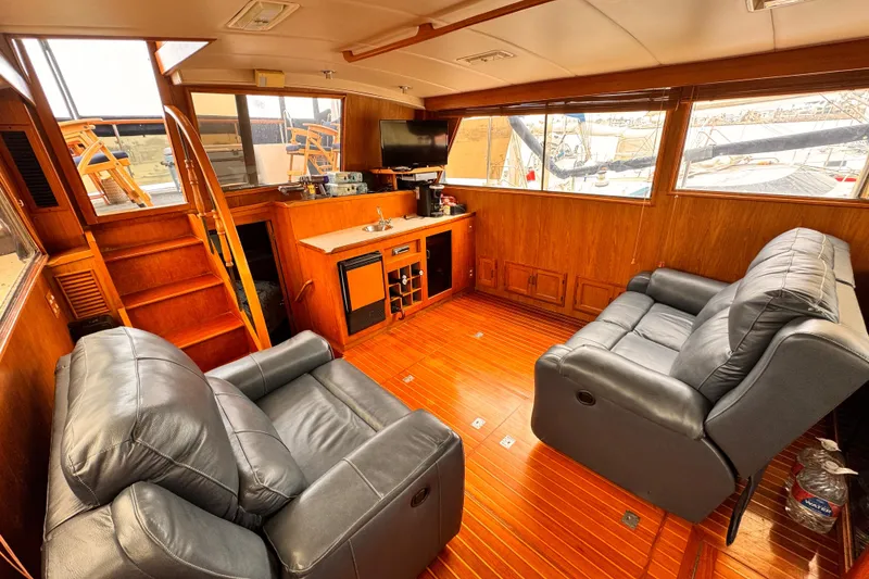 Luxurious 1985 Symbol 51 yacht interior with leather seating and wooden flooring.