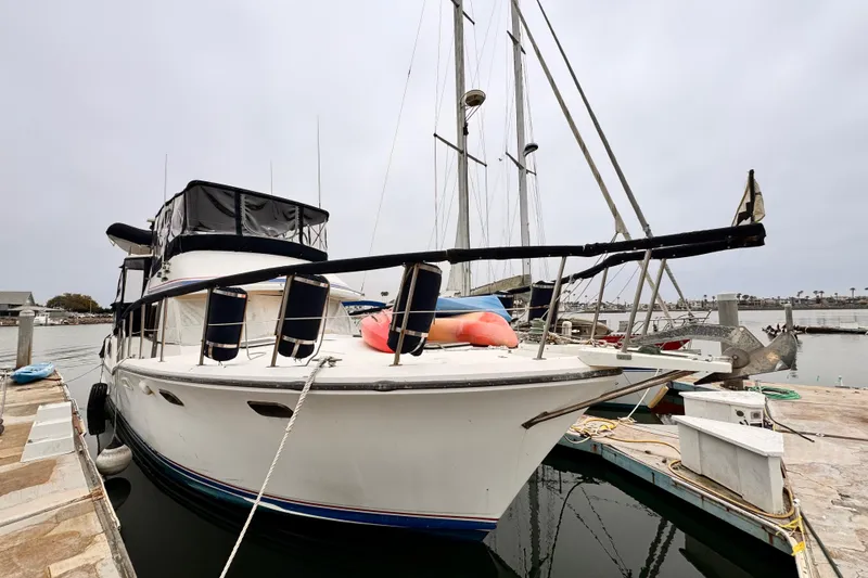 1985 Symbol 51 yacht docked at marina, overcast sky, calm waters.