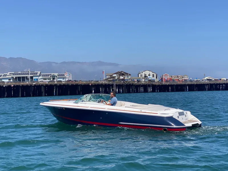 2004 Chris-Craft Corsair 25 boat on water near a pier.