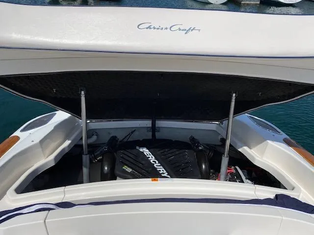 2004 Chris-Craft Corsair 25 with open engine compartment by the water.