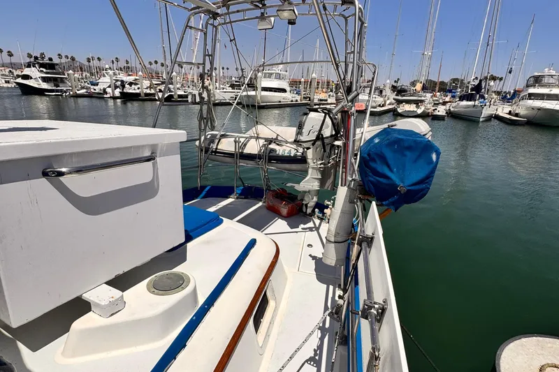 1982 Kelly Peterson 46 sailboat docked in a marina, surrounded by other boats.
