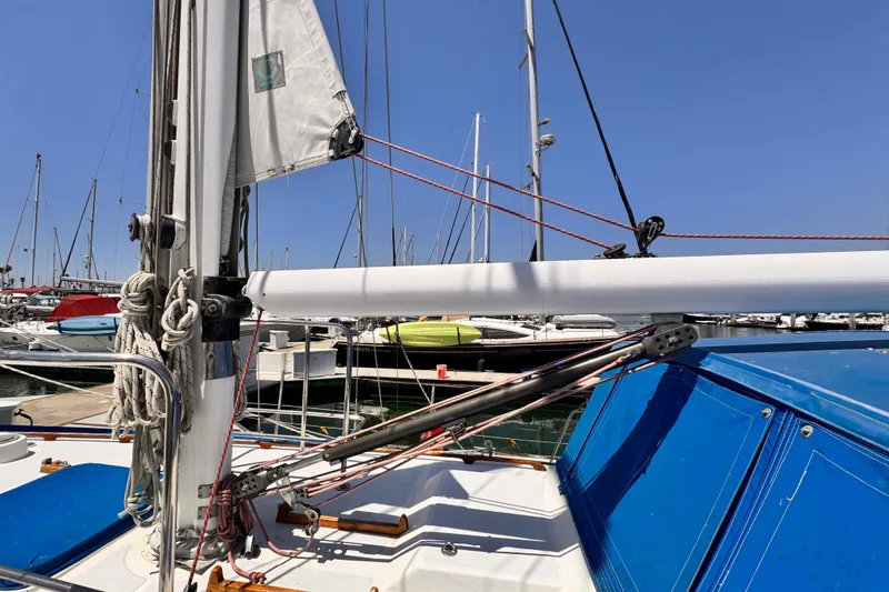 Sailboat deck view, Kelly Peterson 46, 1982 model, docked in marina under clear blue sky.