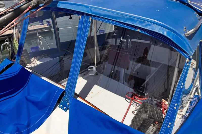 1982 Kelly Peterson 46 sailboat cockpit with blue canopy and visible ropes.