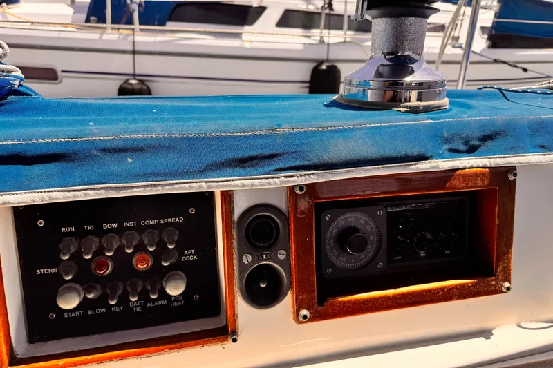 Control panel on a 1982 Kelly Peterson 46 sailboat with blue cover and winch.