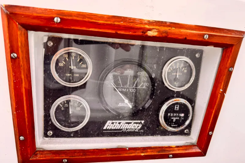 Instrument panel of a 1982 Kelly Peterson 46 sailboat with wooden frame.