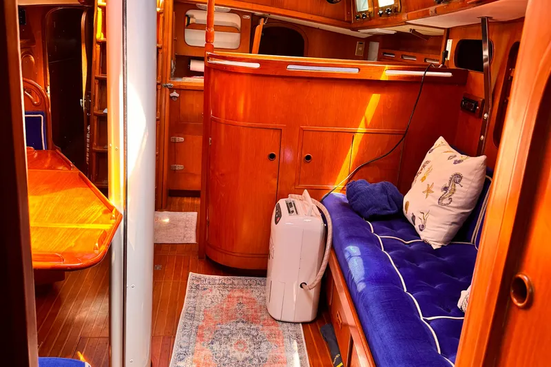 Interior of 1982 Kelly Peterson 46 yacht with wooden furnishings and blue seating.