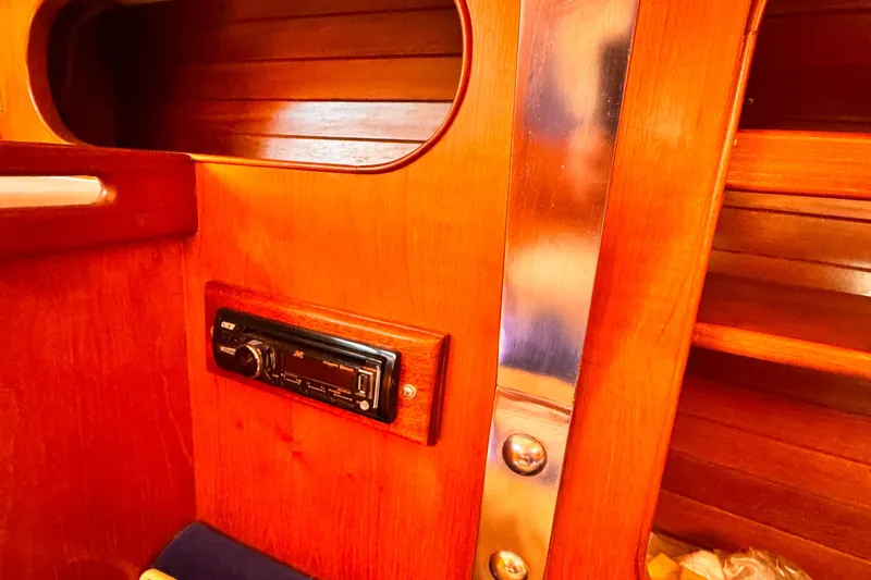 Interior of 1982 Kelly Peterson 46 yacht with wooden paneling and JVC stereo system.
