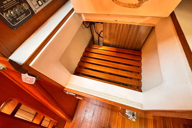 Interior of 1982 Kelly Peterson 46 sailboat with wooden flooring and storage compartment.