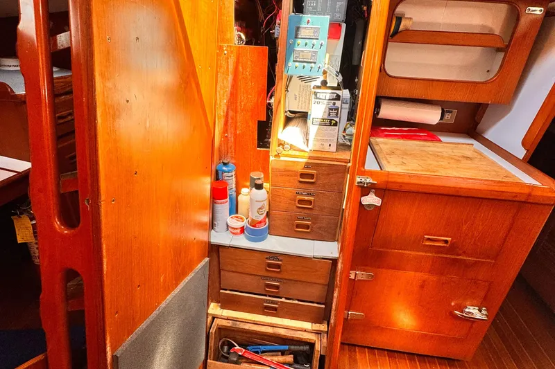 Interior of 1982 Kelly Peterson 46 sailboat with wooden cabinetry and storage compartments.