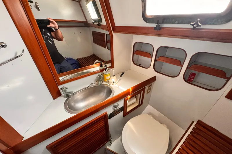 Interior of 1982 Kelly Peterson 46 yacht bathroom with sink, mirror, and toilet.