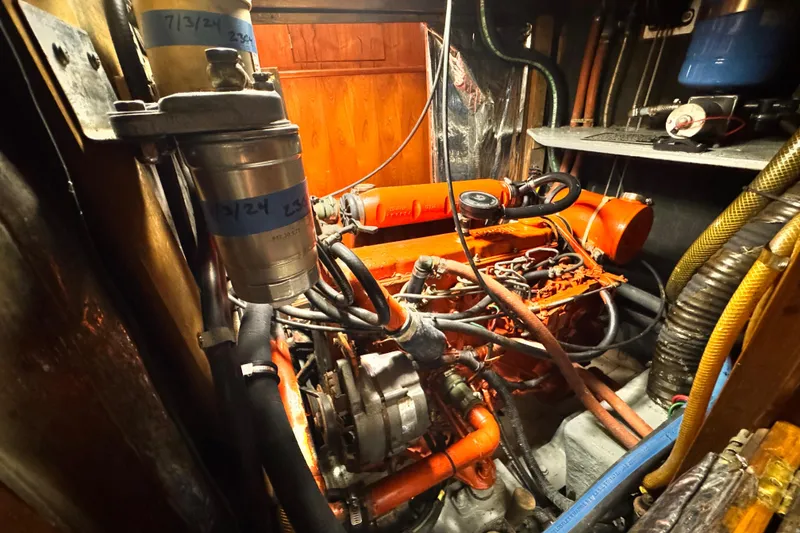 Engine room of a 1982 Kelly Peterson 46 sailboat, showcasing mechanical components and wiring.
