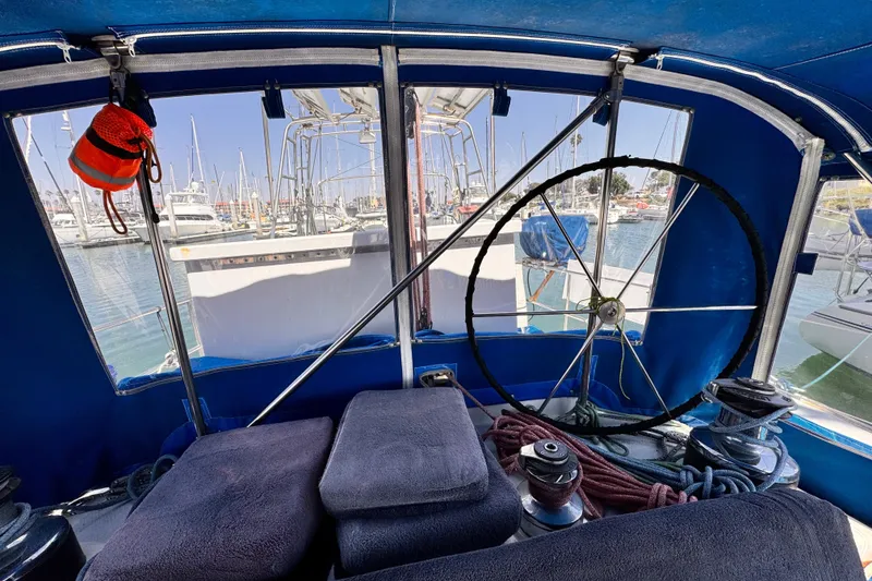 Interior view of a 1982 Kelly Peterson 46 sailboat cockpit with marina background.