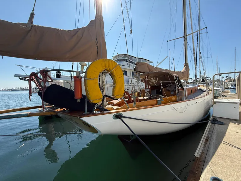 Historic 1932 Fellows & Stewart Yawl docked at marina, featuring classic design and wooden deck.