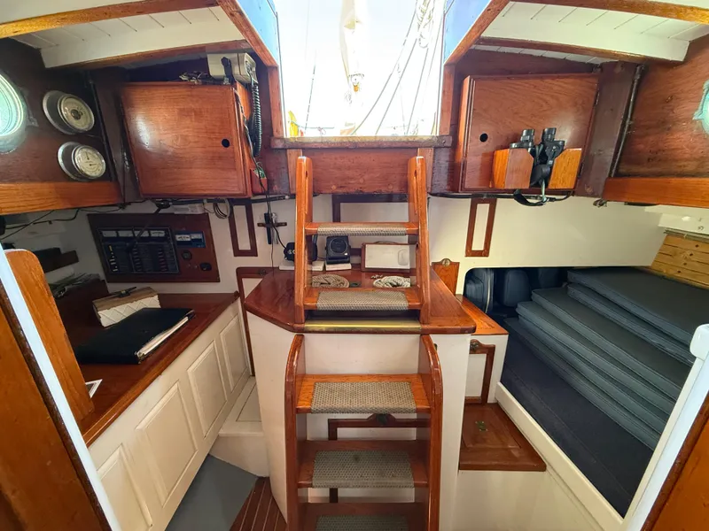 Interior of 1932 Historic Fellows & Stewart Yawl, featuring wooden cabinetry and nautical instruments.