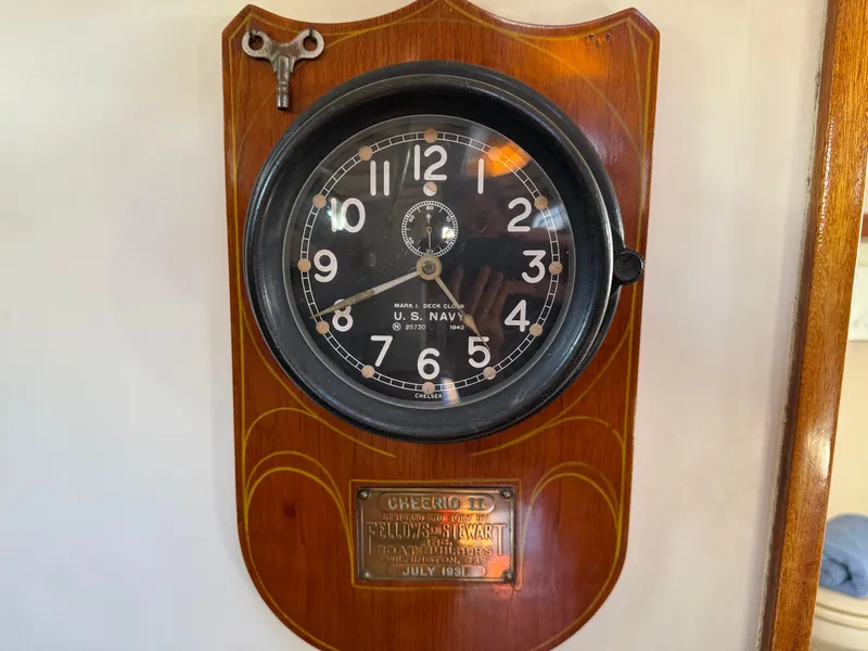 Wall-mounted U.S. Navy clock on 1932 Fellows & Stewart Yawl, with brass plaque and winding key.
