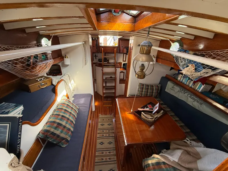 Interior of a 1932 Historic Fellows & Stewart Yawl, featuring cozy seating and nautical decor.