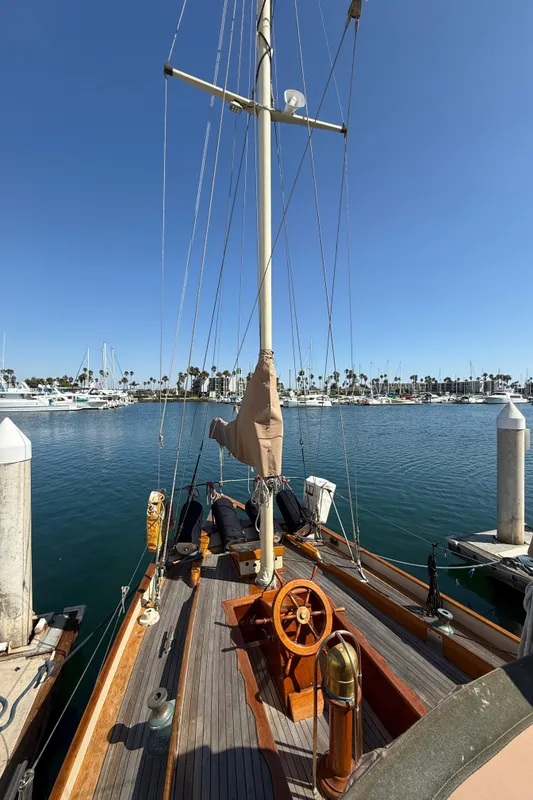 Historic 1932 Fellows & Stewart Yawl docked at a marina under clear blue skies.