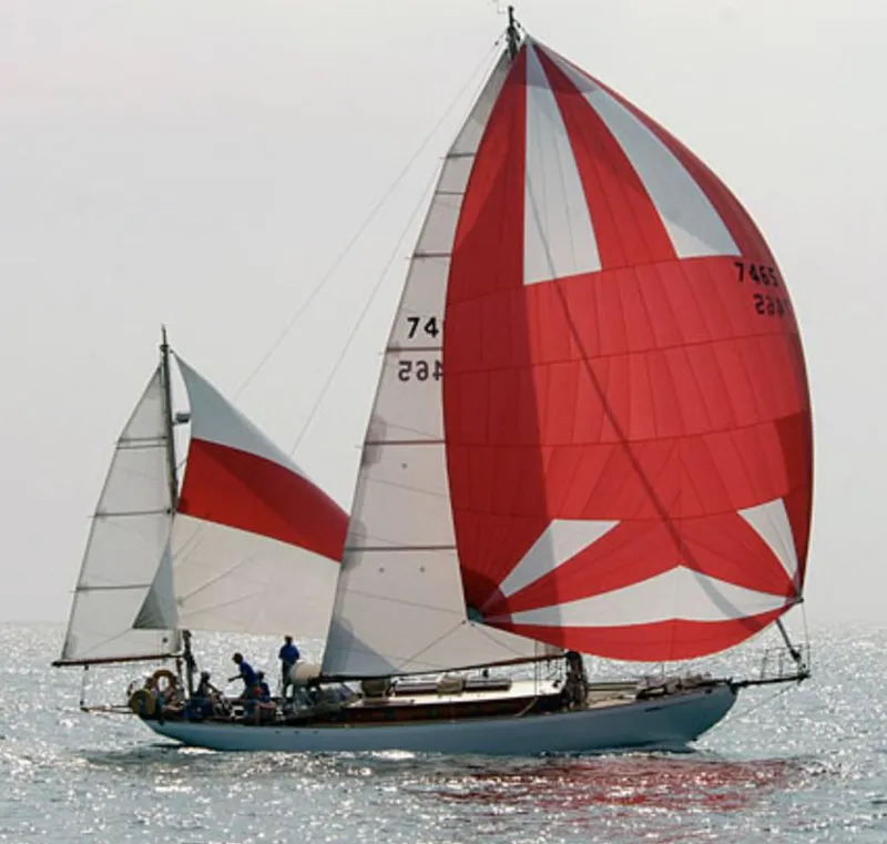 Historic 1932 Fellows & Stewart Yawl sailing with red and white sails on open water.