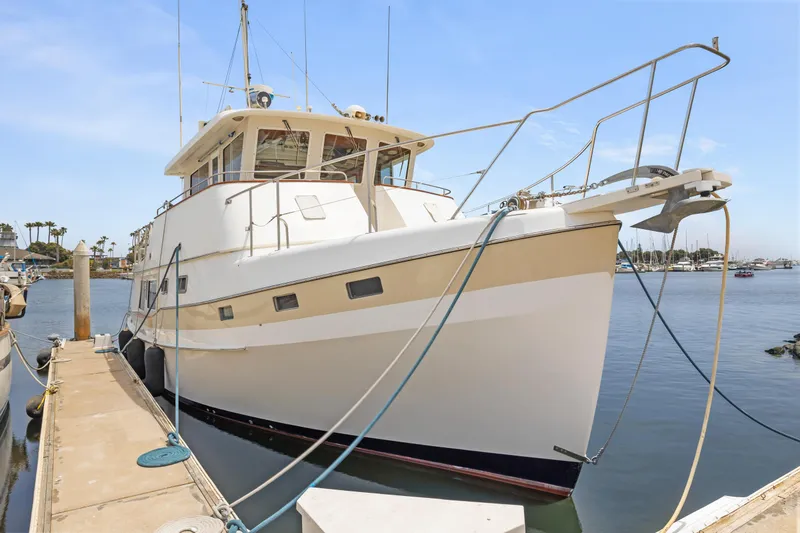 1996 Kadey-Krogen 48 Whaleback yacht docked at marina under clear blue sky.
