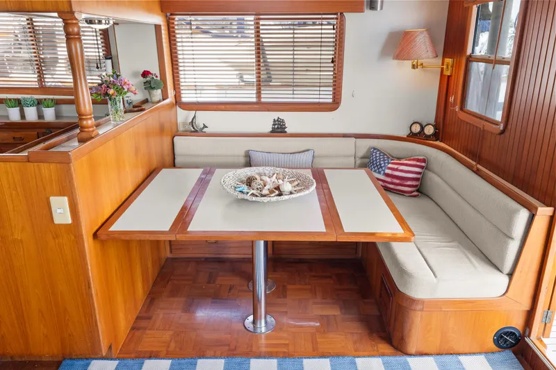 Cozy dining area in 1996 Kadey-Krogen 48 Whaleback yacht with wooden accents and nautical decor.