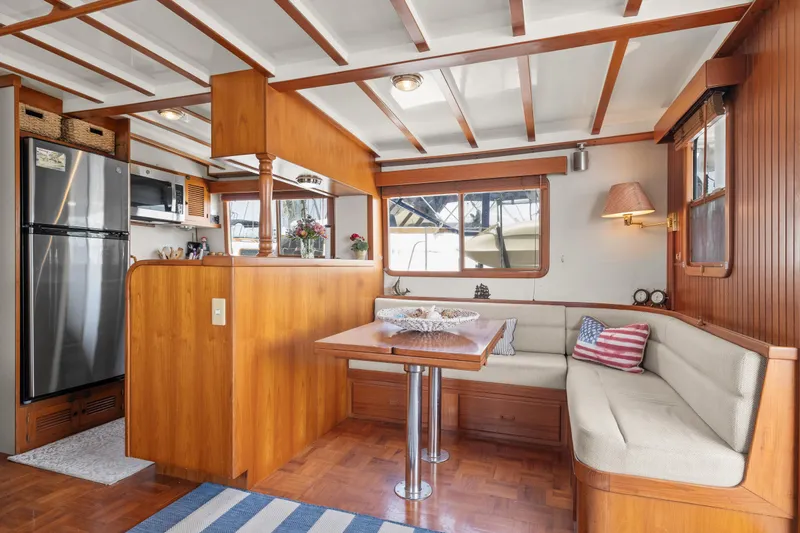 Interior of 1996 Kadey-Krogen 48 Whaleback yacht with cozy dining area and wooden finishes.