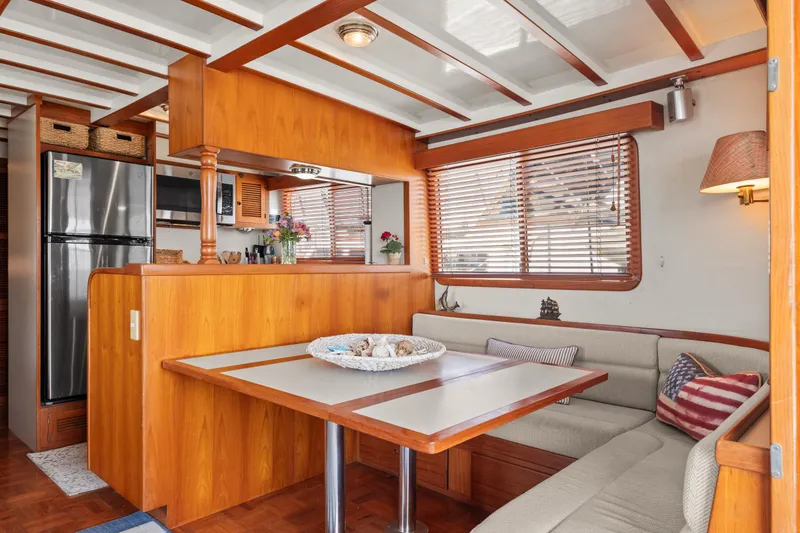 Cozy 1996 Kadey-Krogen 48 Whaleback interior with dining area and kitchen, featuring wood accents.