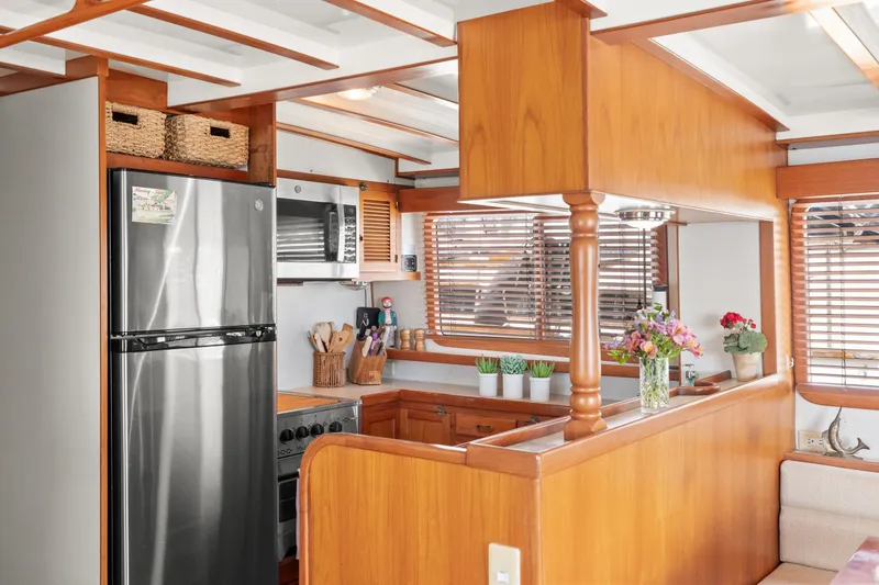 Kadey-Krogen 48 Whaleback 1996 yacht kitchen with wooden cabinetry and stainless steel appliances.