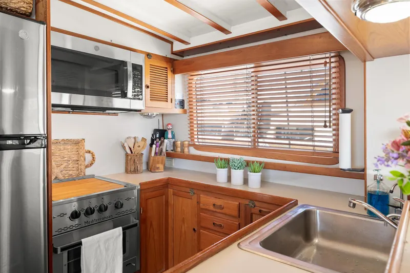Cozy kitchen in 1996 Kadey-Krogen 48 Whaleback yacht with wooden cabinets and modern appliances.