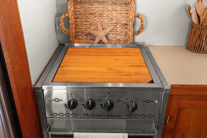 Stove with wooden cover in 1996 Kadey-Krogen 48 Whaleback yacht kitchen.