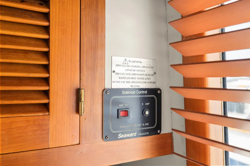 Solenoid control panel on 1996 Kadey-Krogen 48 Whaleback yacht, near wooden blinds and cabinet.