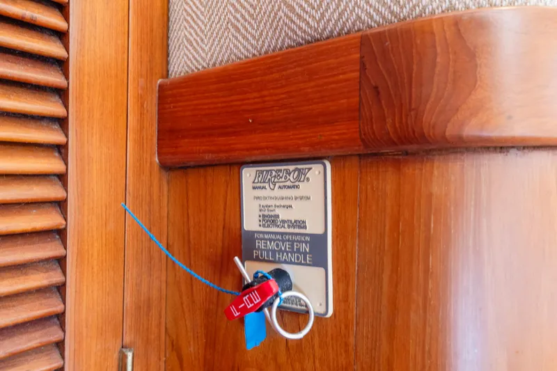 Fire extinguisher pull handle on 1996 Kadey-Krogen 48 Whaleback yacht interior.