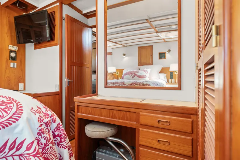 1996 Kadey-Krogen 48 Whaleback cabin interior with wooden furniture and floral bedding.