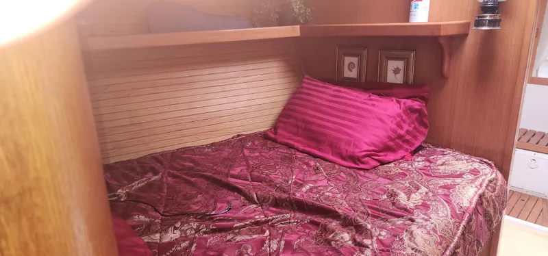 Cozy cabin interior of 1995 Catalina 42 MkII with red bedding and wooden accents.