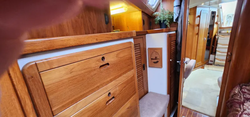 Interior of a 1995 Catalina 42 MkII sailboat with wooden cabinetry and cozy decor.